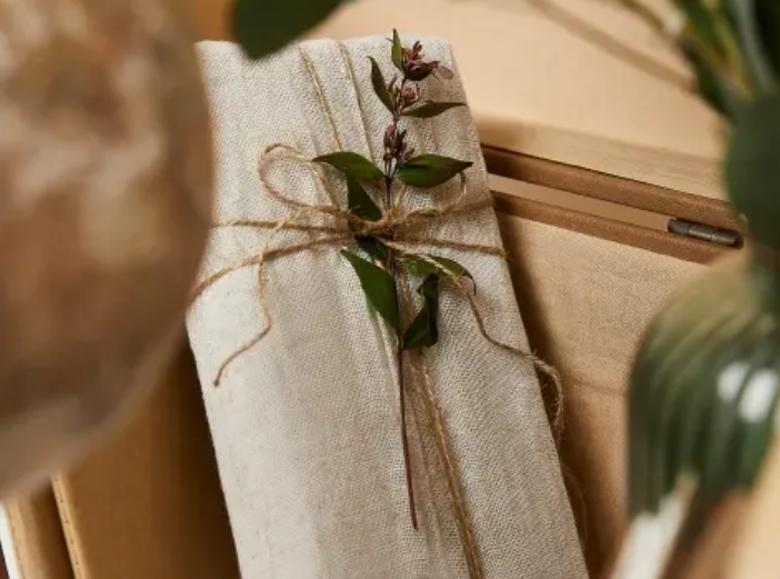 A dried flower rested upon wrinkled pieces of cloth paper.